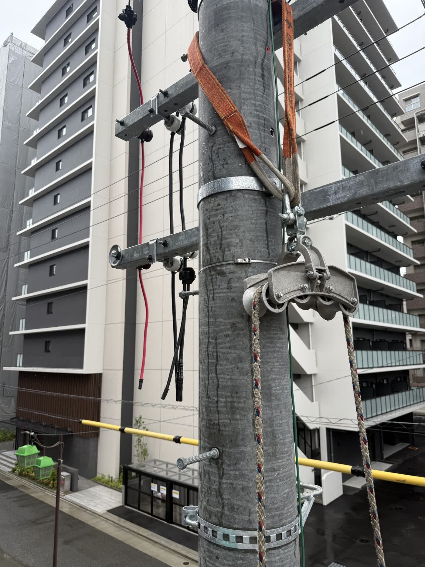 電柱に取り付けた滑車とロープ。マンションへの幹線引き込み工事